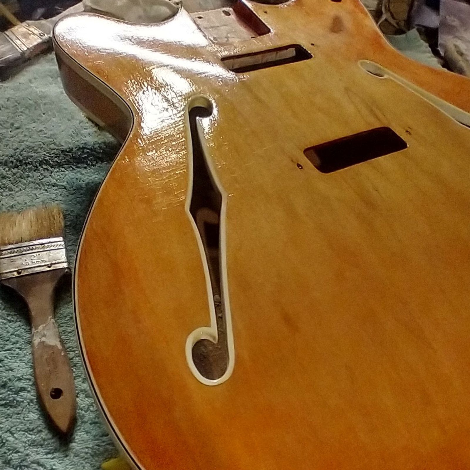 Front of a vintage Fender Coronado II hollow-body guitar mid-restoration, with custom nickel-plated hardware.