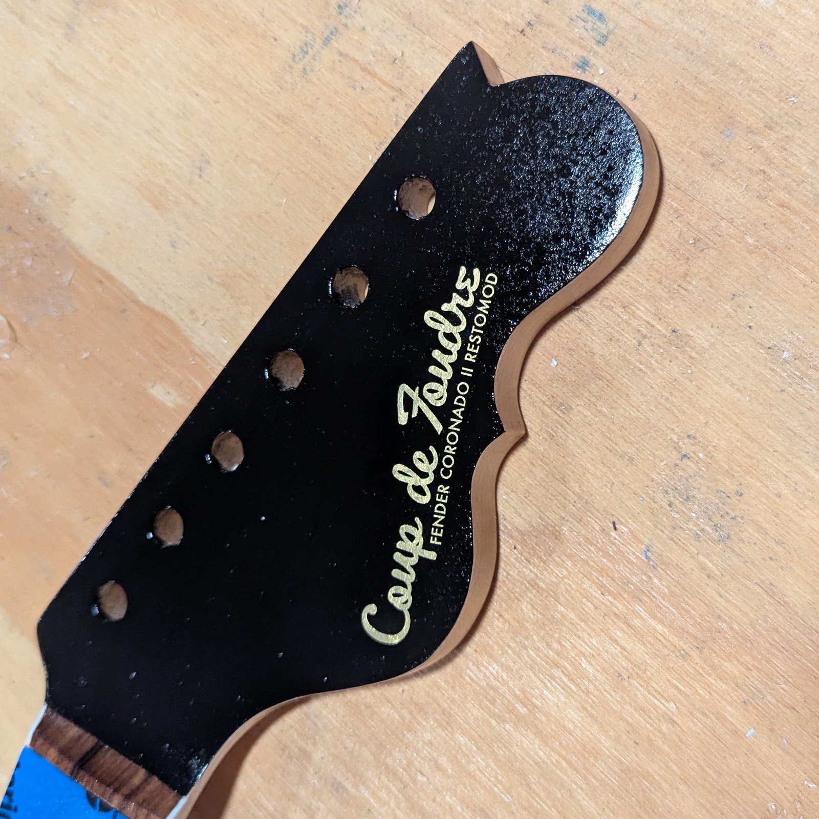 Close-up angle of the Coronado headstock decal and tuners.
